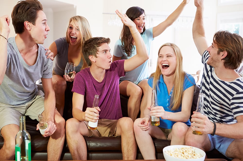 Sports fans on couch high five each other Sports fans on couch high five each other