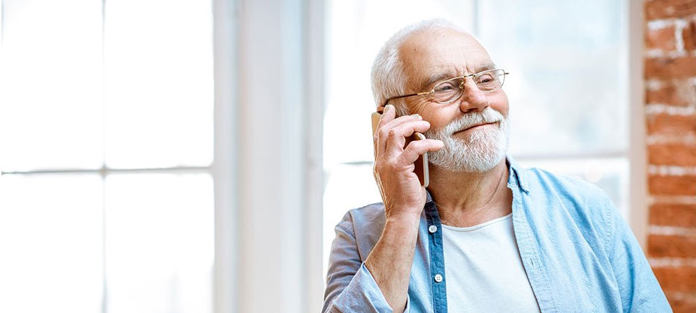 man on phone with white hair and blue shirt man on phone with white hair and blue shirt