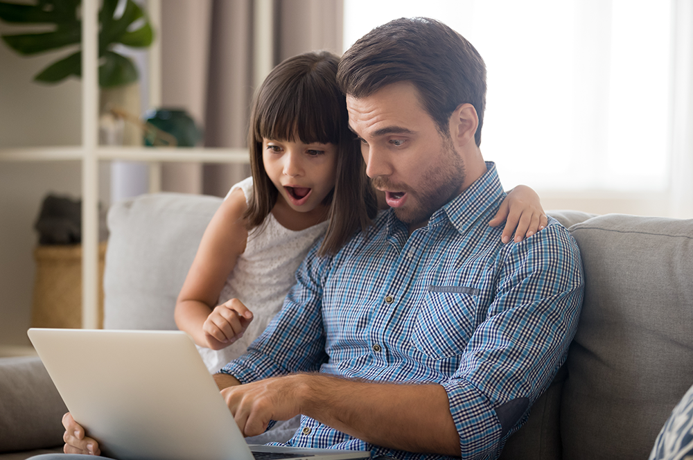 Man and child looking at laptop Man and child looking at laptop