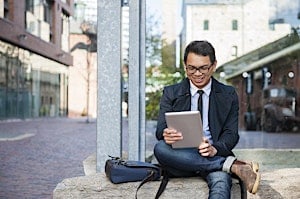 Young Asian man in a business suit using a tabletYoung Asian man in a business suit using a tablet