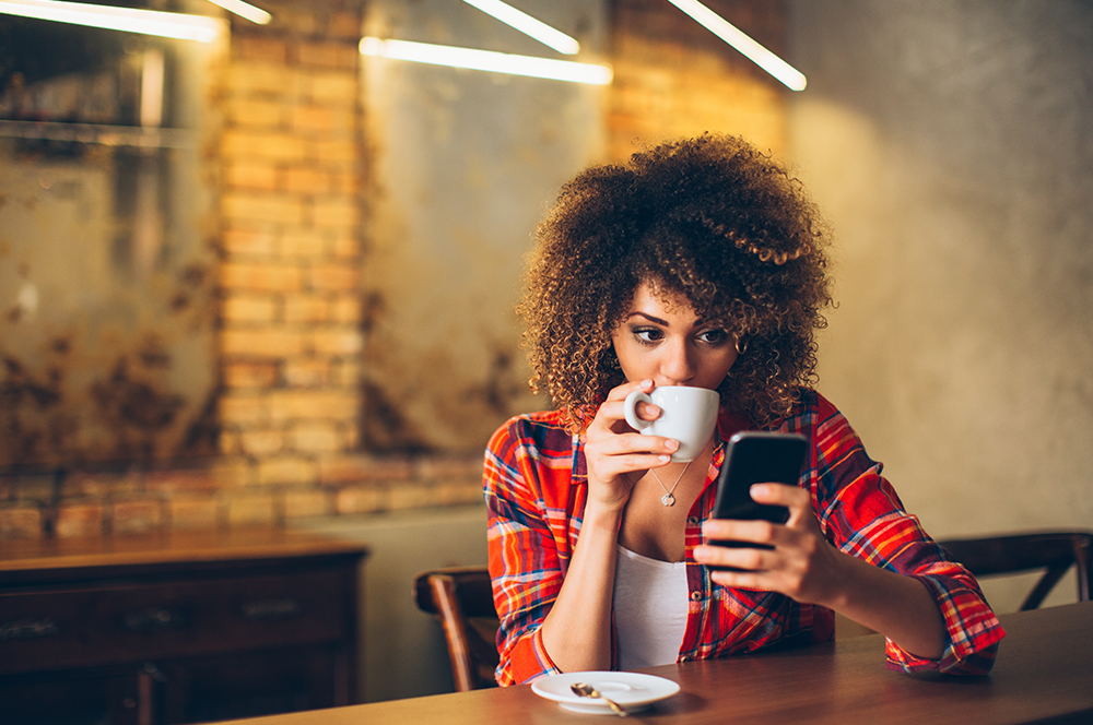 sipping on coffee looking at phone sipping on coffee looking at phone