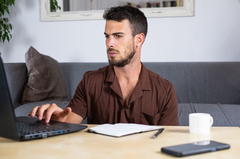 Man sitting on floor concentrating on his computer Man sitting on floor concentrating on his computer